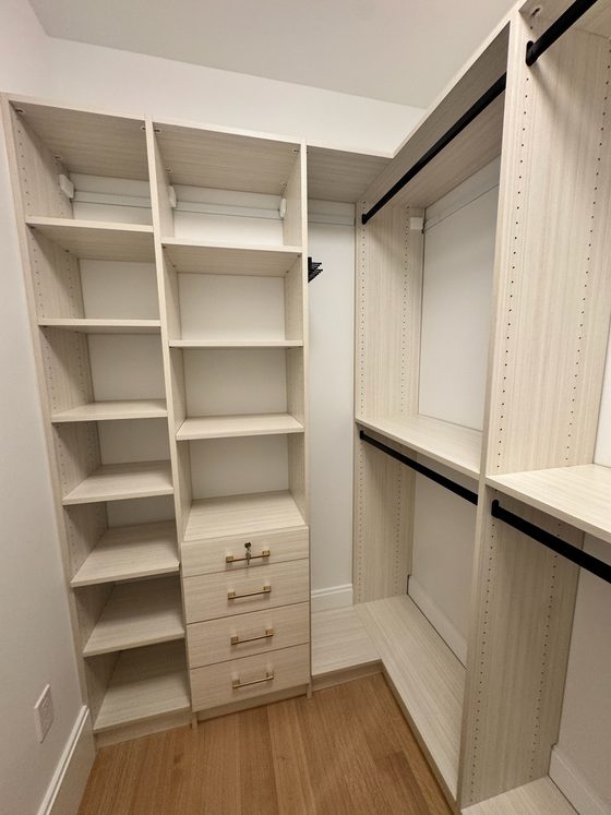 Classic walk in closet in white laminate with lockable drawer unit and brass hardware